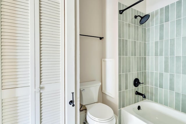 bathroom featuring tiled shower / bath combo and toilet