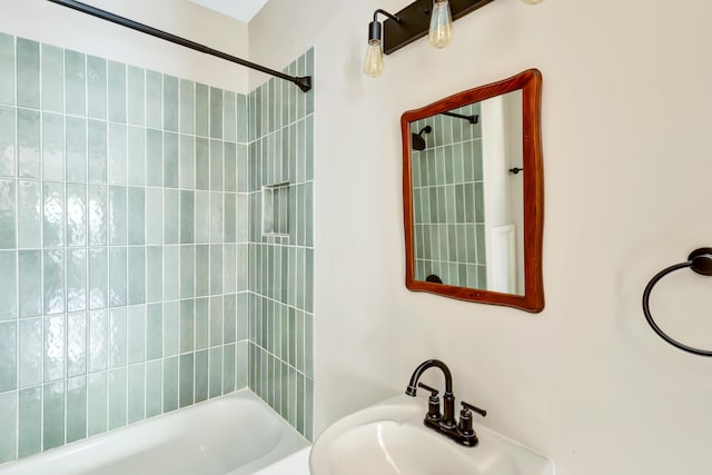 bathroom with tiled shower / bath combo and sink