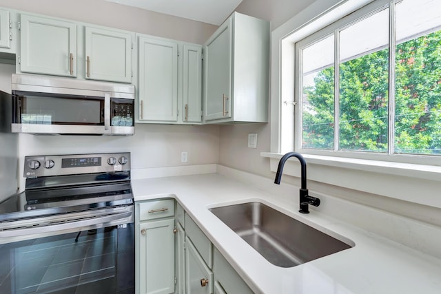 kitchen with sink, stainless steel appliances, and white cabinets