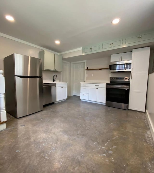 kitchen featuring sink, appliances with stainless steel finishes, concrete flooring, green cabinetry, and white cabinets