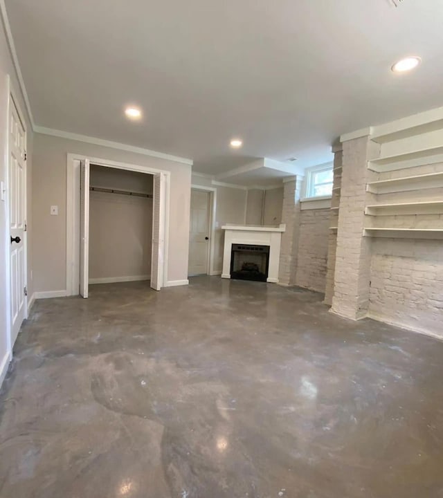 unfurnished living room with ornamental molding and concrete floors