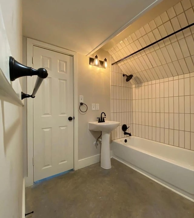 bathroom featuring concrete flooring and tiled shower / bath