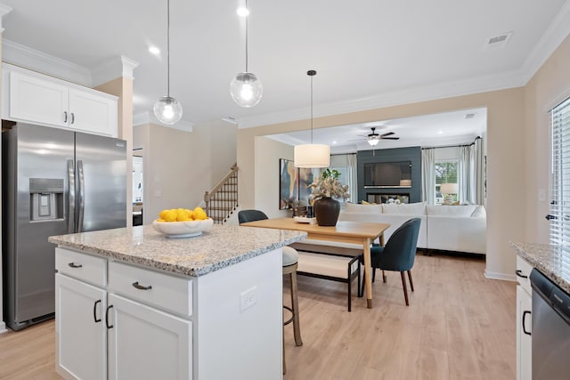 kitchen with a breakfast bar area, ceiling fan, a kitchen island, white cabinetry, and stainless steel appliances