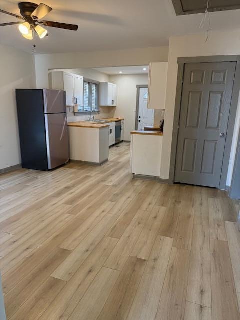 kitchen with ceiling fan, white cabinets, light wood-type flooring, and appliances with stainless steel finishes