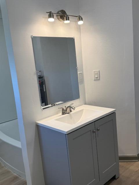 bathroom with vanity, a bathtub, and hardwood / wood-style floors