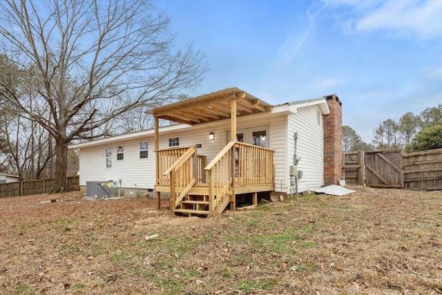 back of property with central AC unit and a deck