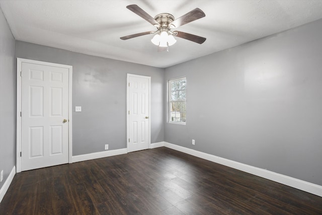 unfurnished room with a textured ceiling, ceiling fan, and dark wood-type flooring