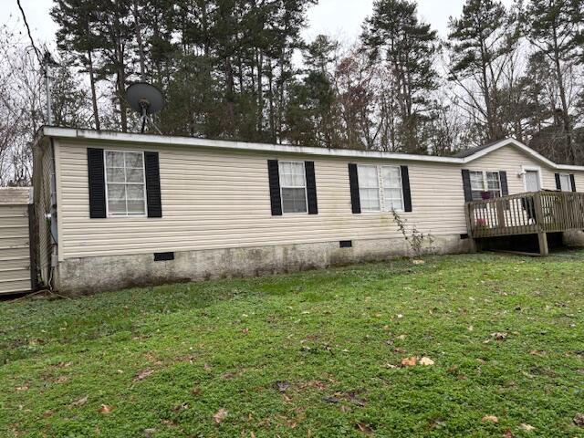 exterior space with a deck and a lawn