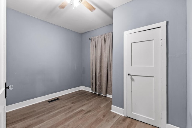 unfurnished room with ceiling fan and hardwood / wood-style flooring