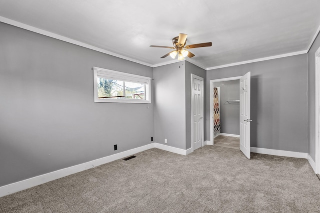 unfurnished bedroom featuring carpet flooring, ceiling fan, and crown molding