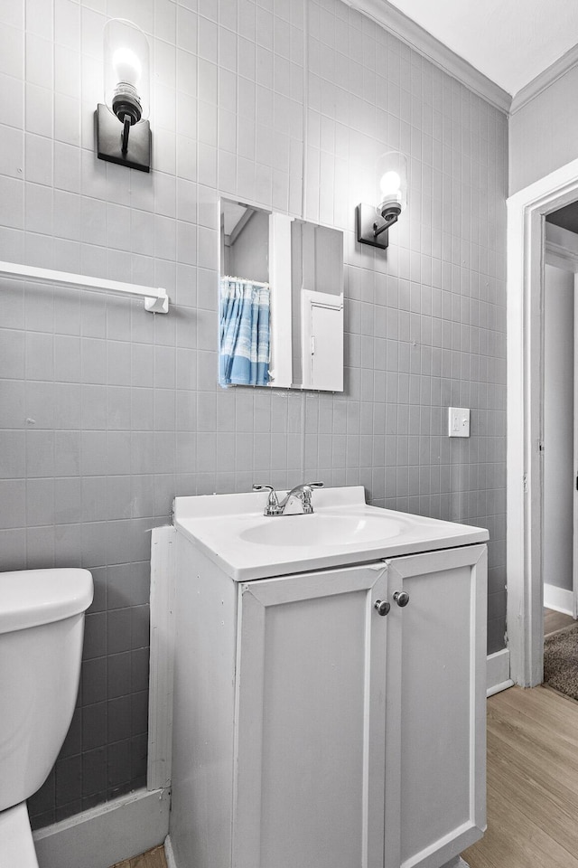 bathroom featuring hardwood / wood-style floors, vanity, toilet, and tile walls