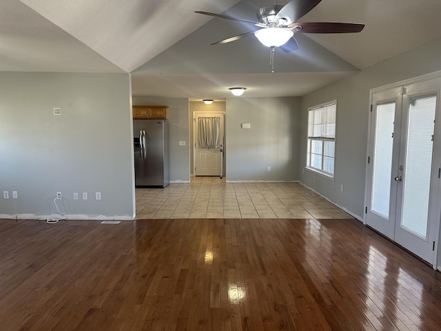 empty room featuring ceiling fan, lofted ceiling, and light hardwood / wood-style flooring