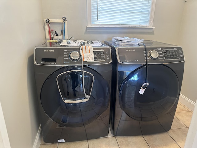 clothes washing area with washing machine and dryer and tile patterned floors