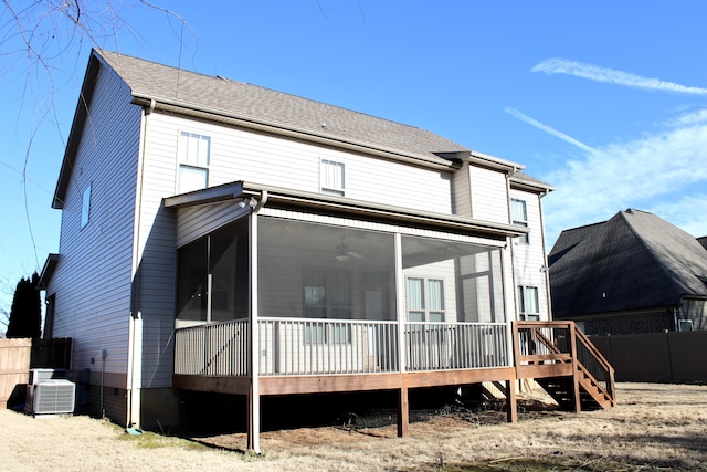 rear view of house featuring cooling unit and a sunroom