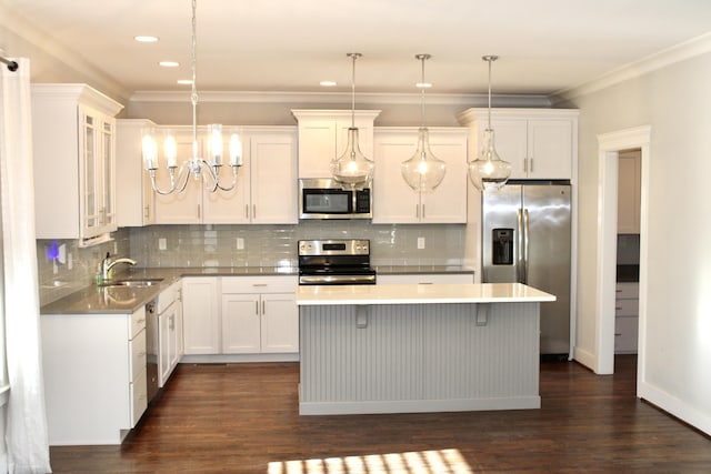 kitchen with stainless steel appliances, decorative light fixtures, and white cabinets