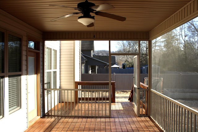 unfurnished sunroom with wood ceiling and ceiling fan