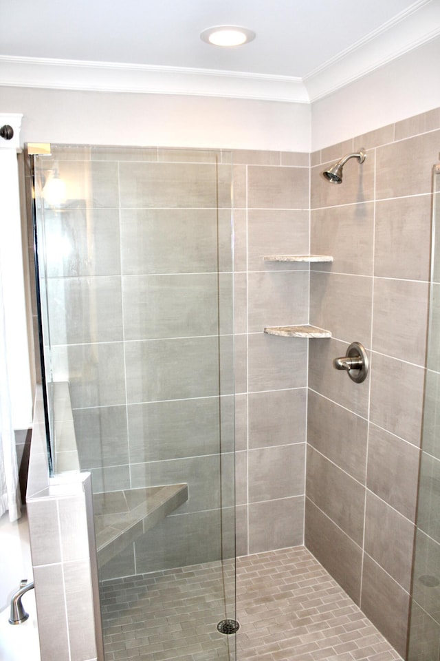 bathroom featuring crown molding and an enclosed shower