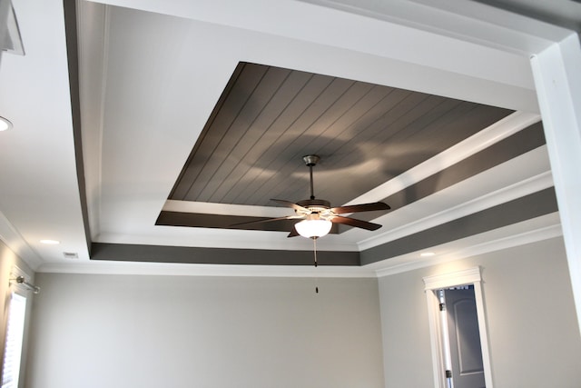 interior details featuring crown molding, ceiling fan, and a tray ceiling