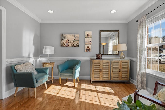 sitting room with crown molding and hardwood / wood-style flooring