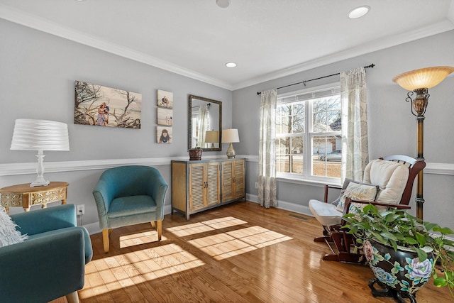 sitting room with wood-type flooring and ornamental molding