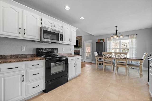 kitchen featuring hanging light fixtures, white cabinets, black electric range, a notable chandelier, and light tile patterned flooring