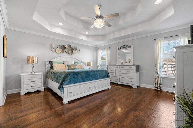 bedroom with multiple windows, a tray ceiling, ceiling fan, and ornamental molding