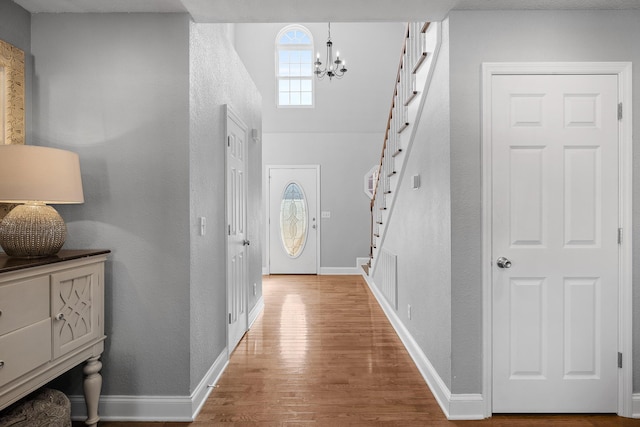 entrance foyer with hardwood / wood-style floors and a notable chandelier