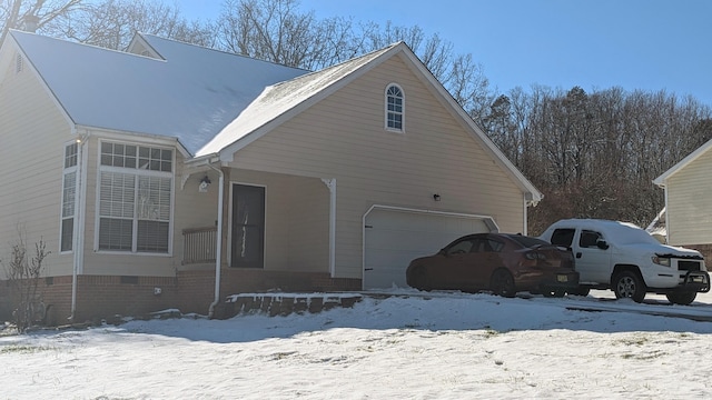 snow covered property featuring a garage