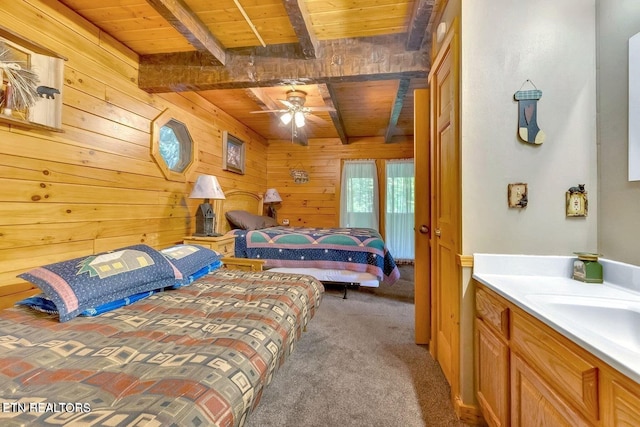 carpeted bedroom with wooden ceiling, sink, wooden walls, ceiling fan, and beamed ceiling