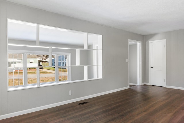 unfurnished room with dark hardwood / wood-style flooring and a textured ceiling