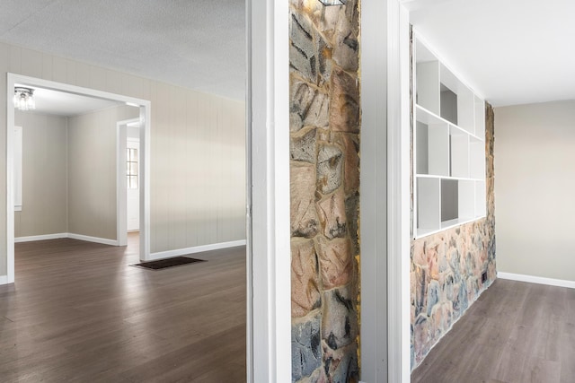 hallway featuring a textured ceiling and dark hardwood / wood-style floors