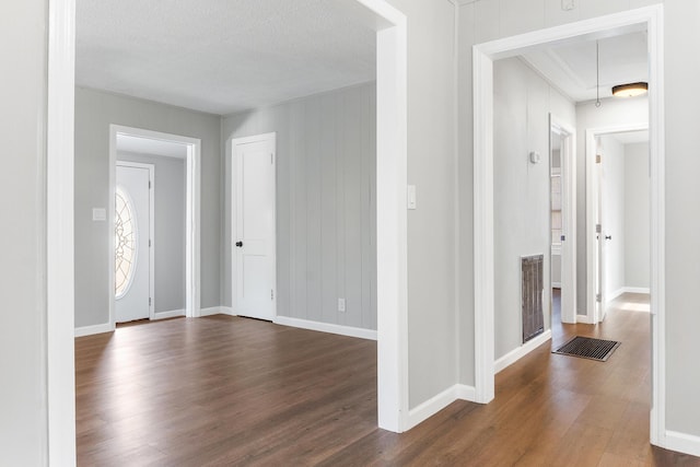 entryway with a textured ceiling and dark hardwood / wood-style floors