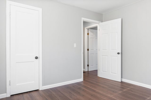 unfurnished bedroom with a closet and dark wood-type flooring