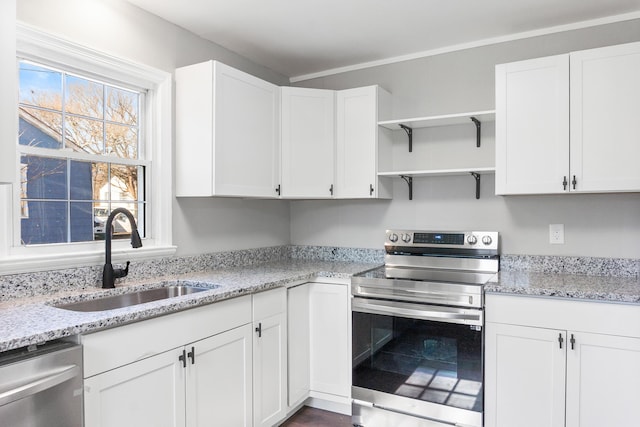 kitchen featuring white cabinetry, sink, light stone countertops, and appliances with stainless steel finishes