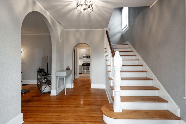 foyer entrance featuring wood-type flooring and ornamental molding