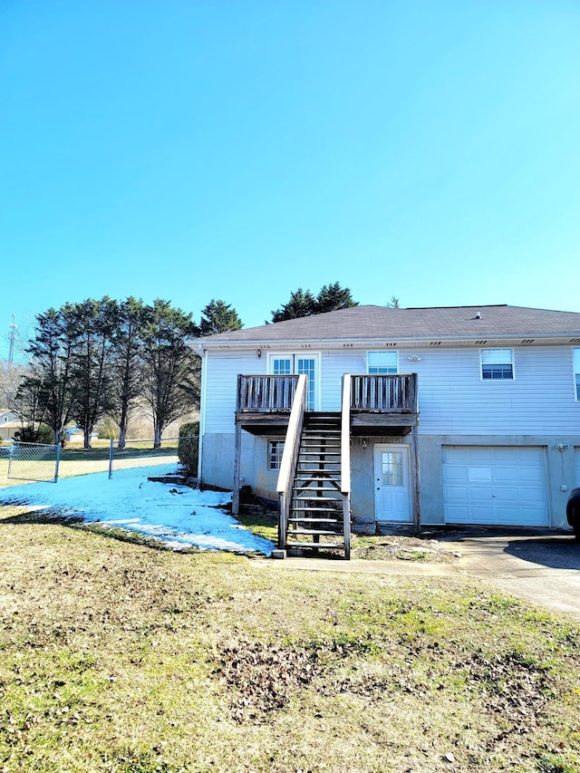 view of front of house with a garage, a deck, and a front lawn