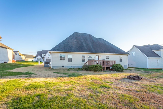 rear view of property with a yard, an outdoor fire pit, and a wooden deck