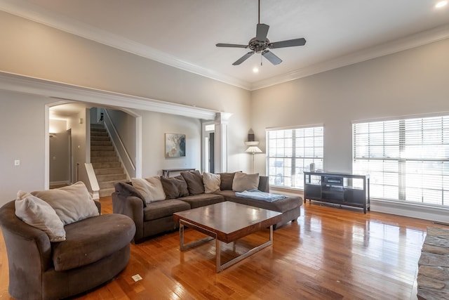 living room with hardwood / wood-style floors, ceiling fan, and ornamental molding