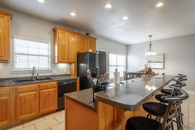 kitchen with a center island, black appliances, a kitchen breakfast bar, sink, and light tile patterned floors