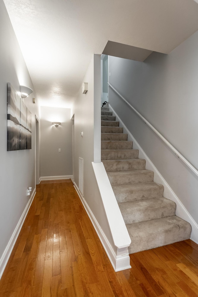 stairs with hardwood / wood-style flooring