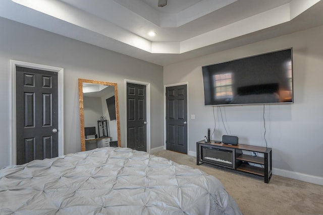 carpeted bedroom with a tray ceiling