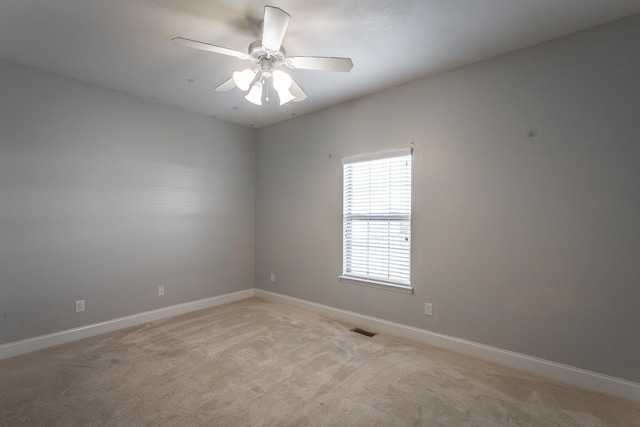 spare room featuring light colored carpet and ceiling fan