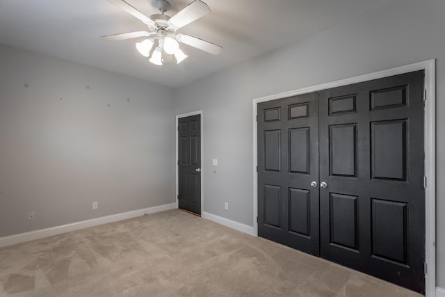 unfurnished bedroom with ceiling fan, a closet, and light colored carpet