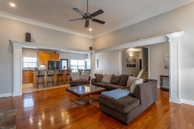 living room featuring a wealth of natural light, crown molding, and ceiling fan