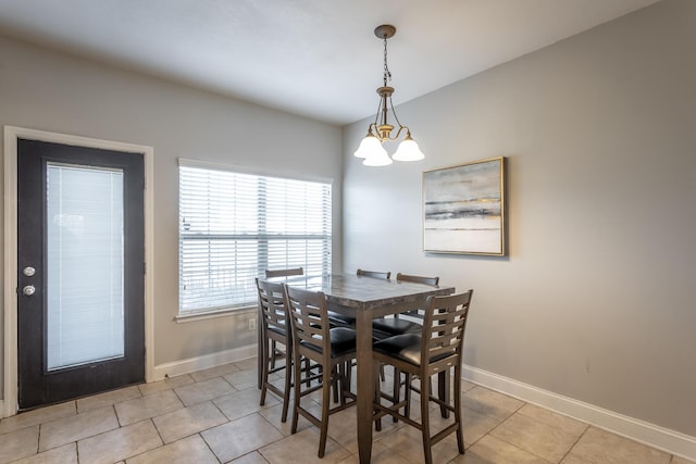 dining room with light tile patterned floors and a chandelier