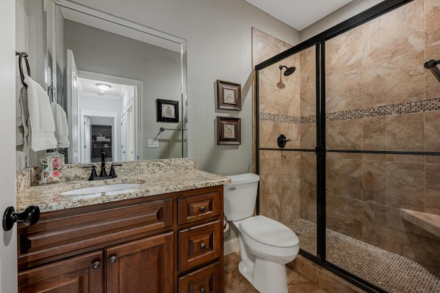 full bathroom featuring crown molding, toilet, a shower stall, vanity, and tile patterned flooring