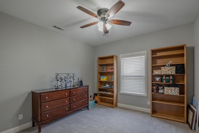 interior space with baseboards, ceiling fan, visible vents, and light colored carpet