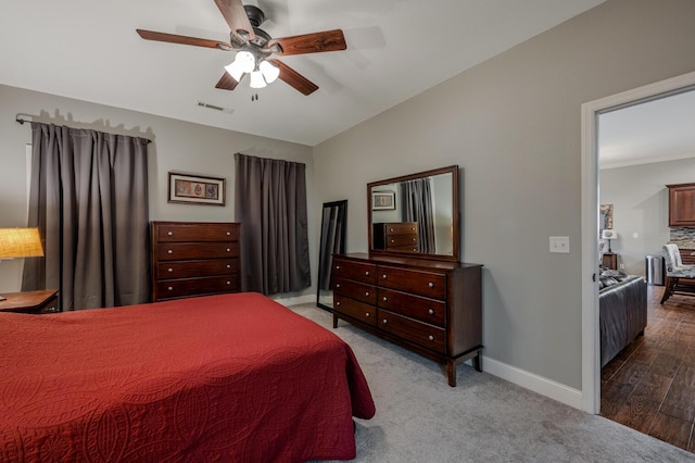 carpeted bedroom featuring a ceiling fan, lofted ceiling, visible vents, and baseboards