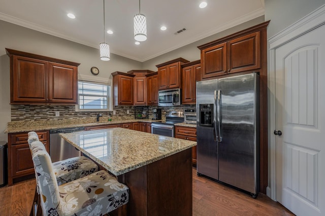 kitchen featuring visible vents, appliances with stainless steel finishes, dark wood-type flooring, hanging light fixtures, and crown molding