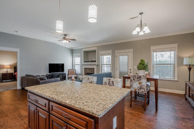 kitchen featuring crown molding, a fireplace, dark wood finished floors, and hanging light fixtures